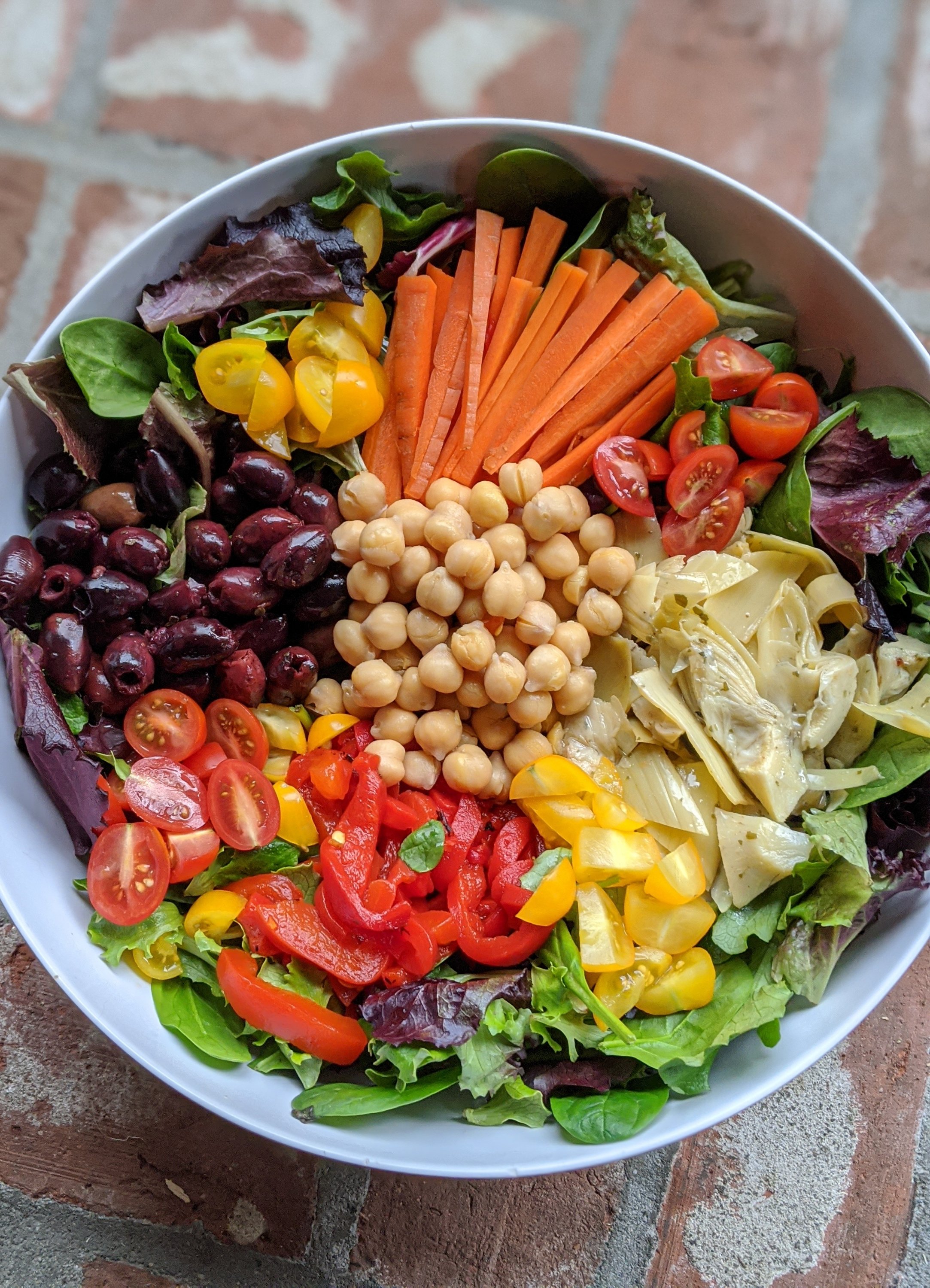 vegan greek salad with chickpeas olives artichoke hearts lettuce feta carrots tomatoes and violife vegan feta cheese substitute for salads