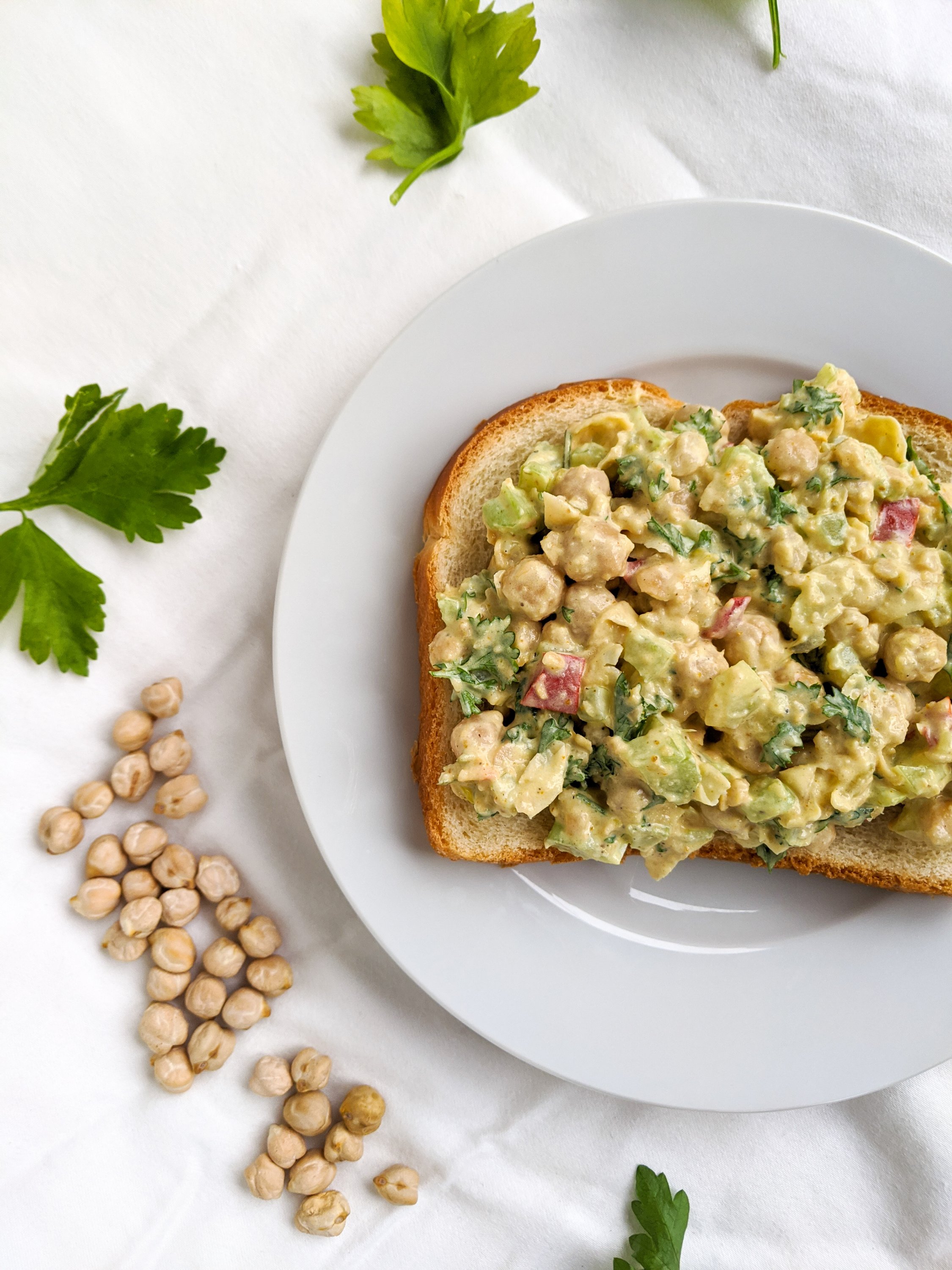 tahini chickpea salad sandwich on bread with high protein vegan chickpeas and parsley for flavor