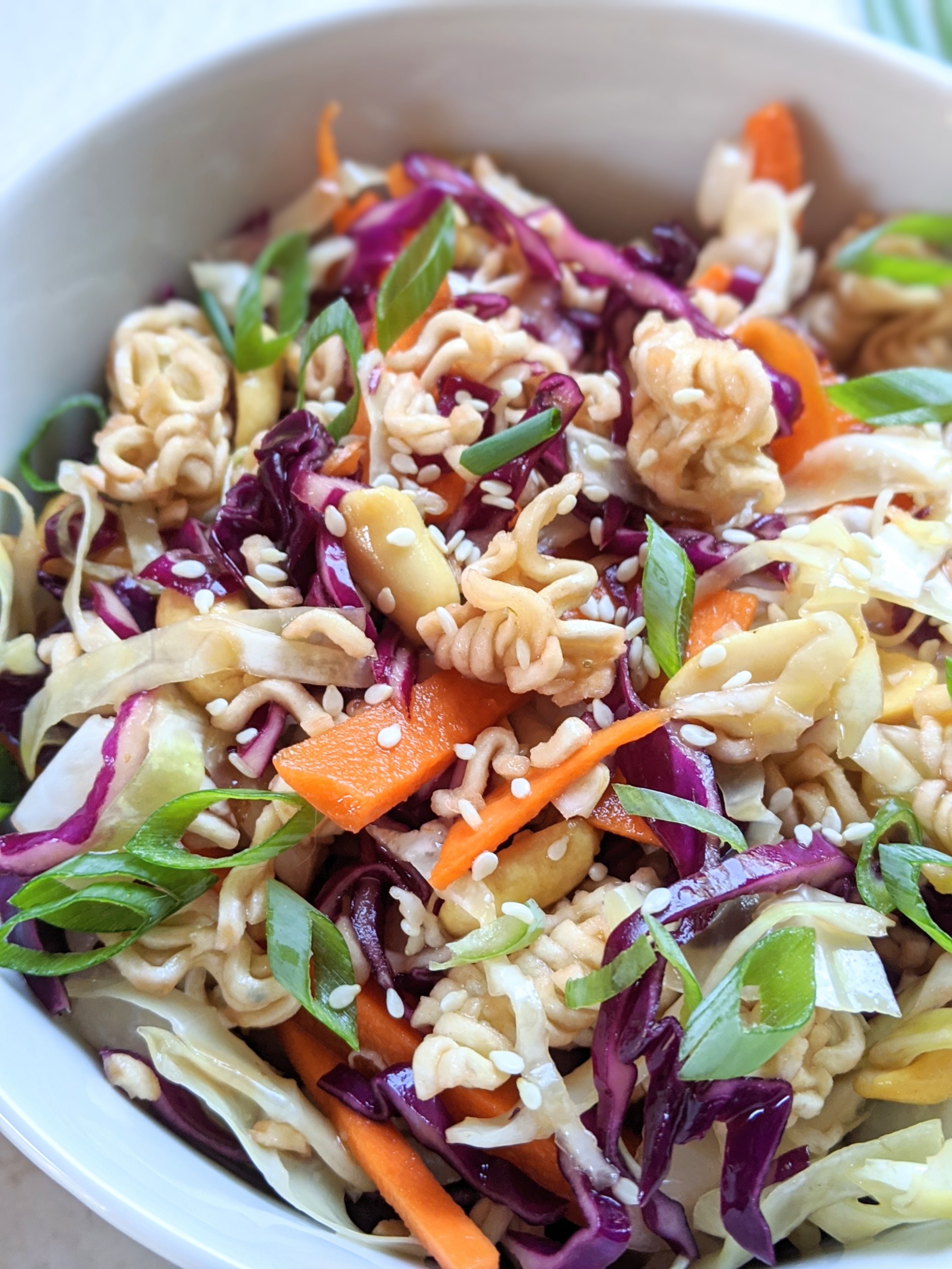 ramen salad with carrots cabbage and green onion in a bowl with sesame seeds