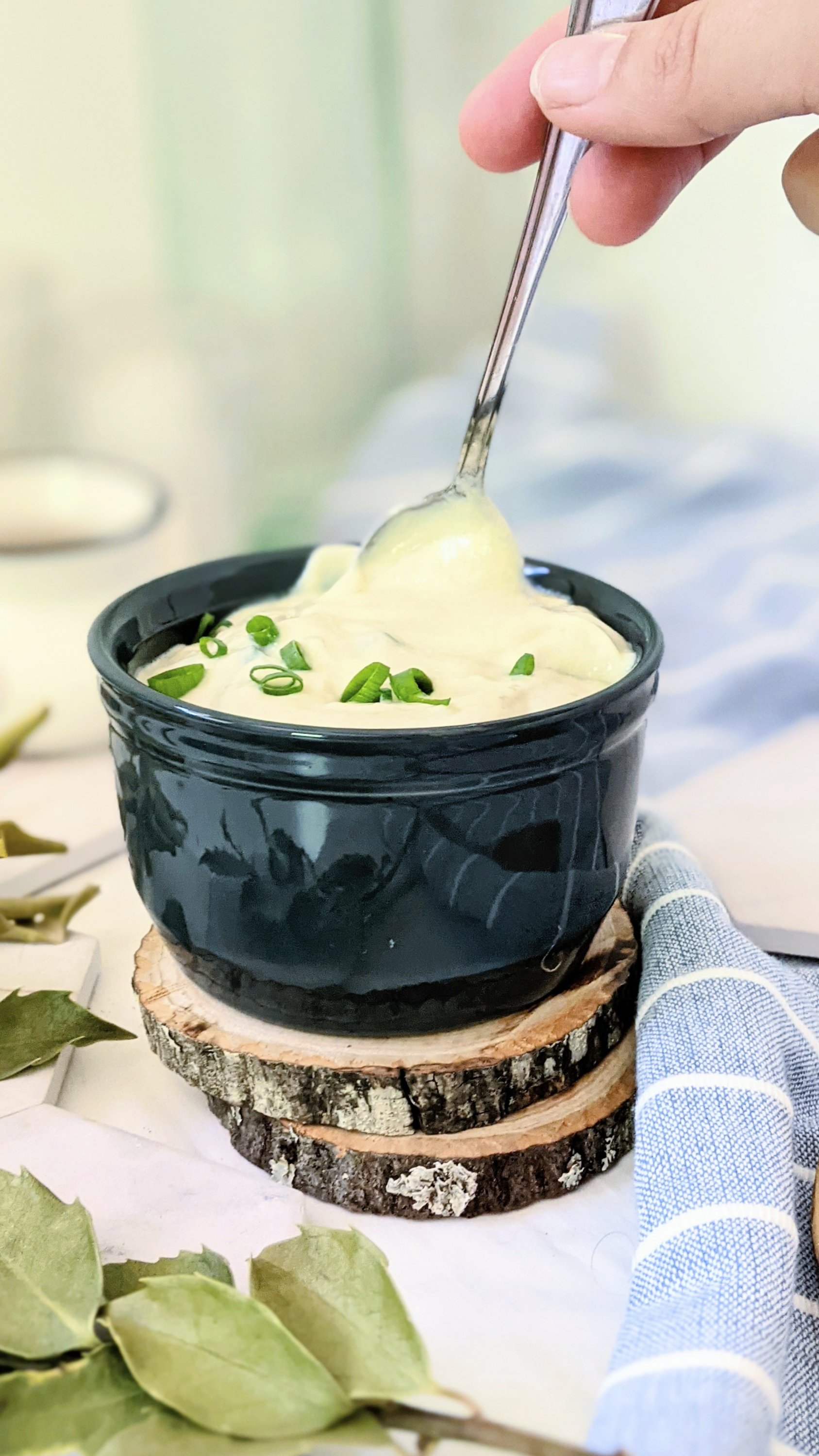 a spoon dipping into creamy vegan garlic sauce for vegetables shawarms and kebab dairy free falafel sauce gluten free healthy sauces made with silken tofu garlic sauce
