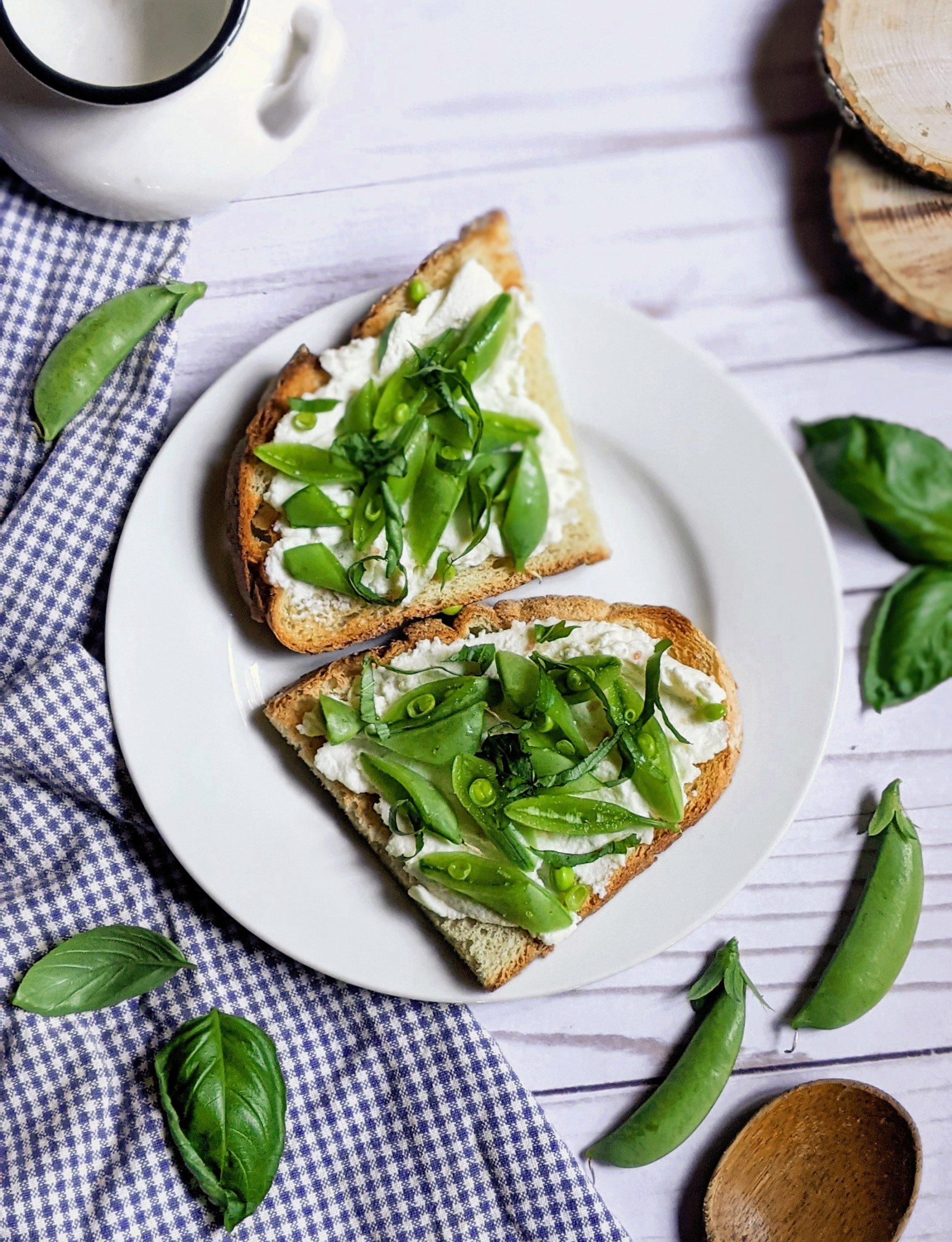 garlic toast with snap pea ricotta toasts on a plate with basil and fresh snap pea recipes