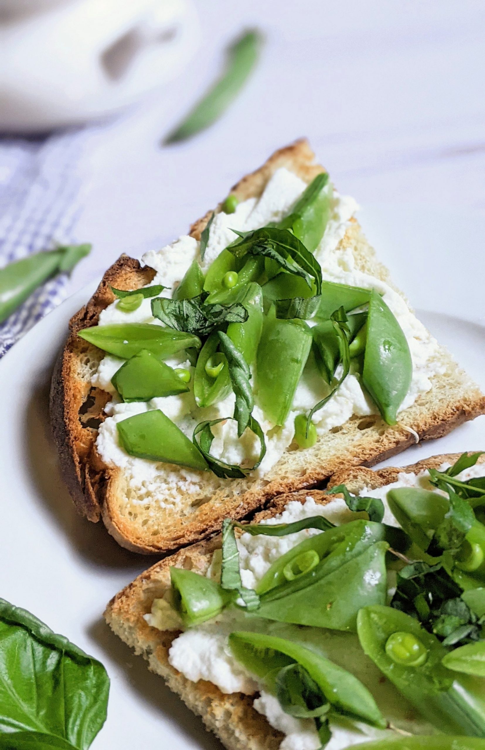 close up of ricotta toast with snap peas and basil breakfast toast with fresh peas