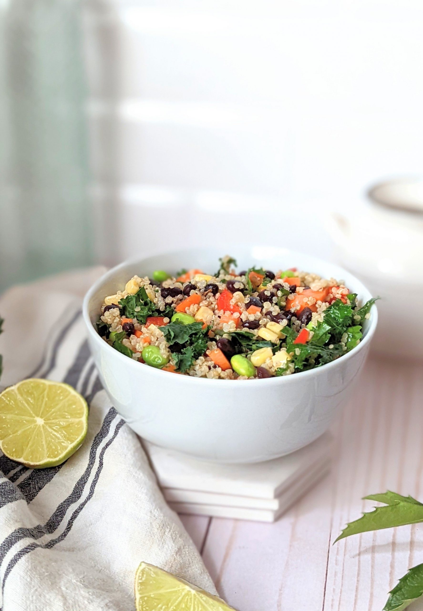 high fiber quinoa salad recipe with beans avocado corn and red chili pepper flakes in a bowl with fresh lime juice dressing