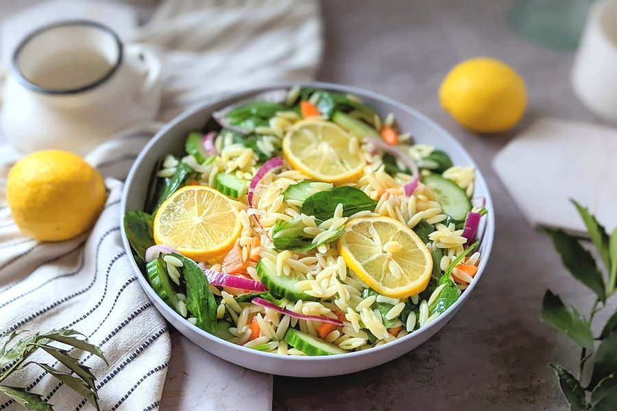 lemon pasta salad with cucumber onion spinach and a lemon dressing with vinaigrette healthy vegan pasta salad with orzo noodles.