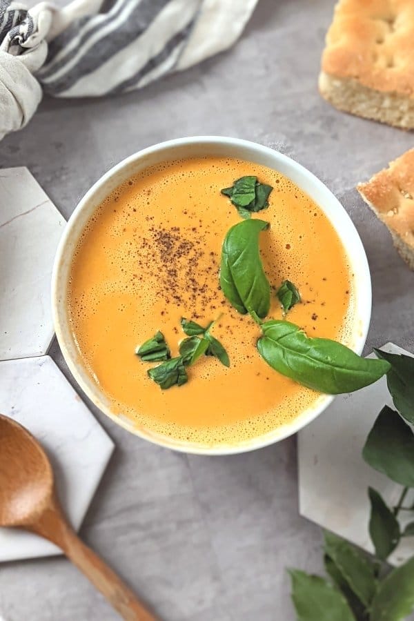 creamy vegan tomato soup in the blender no cook tomato soup recipe with cashews canned diced tomatoes garlic and fresh basil.