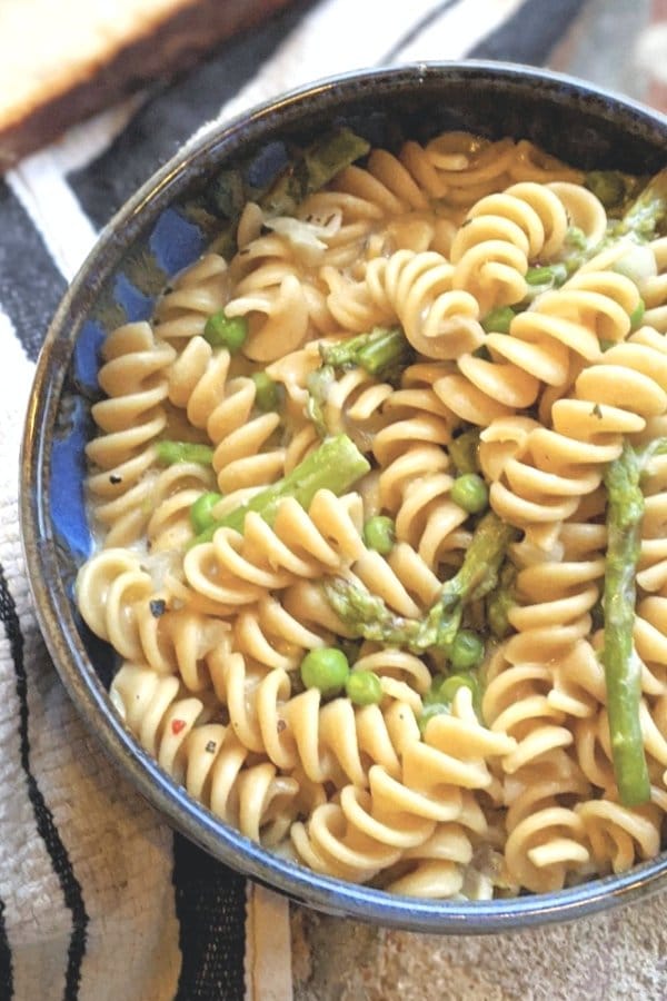 veggie primavera pasta recipe with asparagus and peas and a thick and creamy sauce that is vegetarian and can be gluten free.