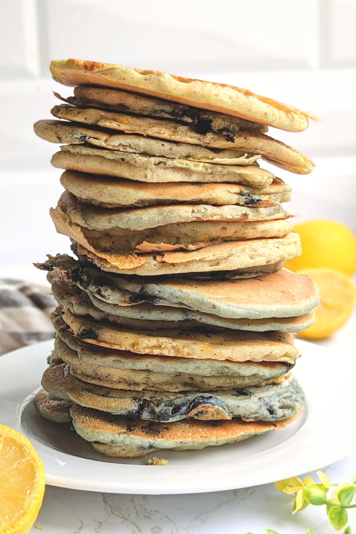 stack of blueberry lemon pancakes with fresk real pure maple syrup on a plate with lemons