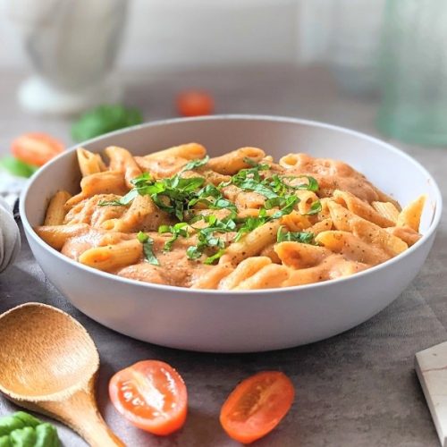 dairy free vodka pasta sauce without cream recipe with a napkin, tomatoes, and basil for garnish. .