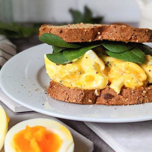 egg mayonnaise sandwich with spinach dill relish and gluten free or low carbohydrate bread on a plate with hardboiled eggs.