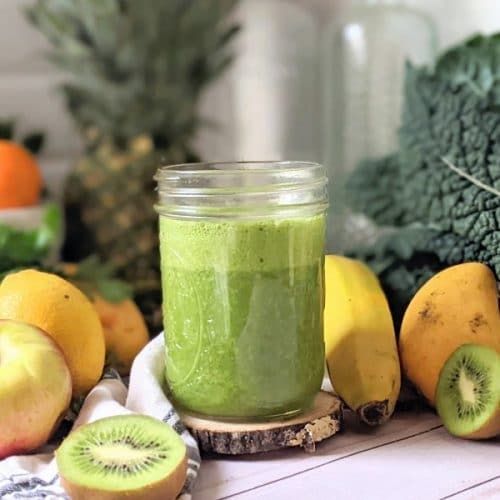 green smoothie with kiwi spinach apples pineapple kale mango and green goddess juice in a blender, vegan and gluten free.