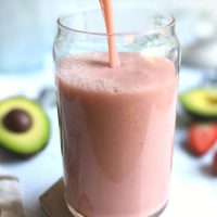avocado smoothie with strawberries and avocadoes blended together poured into a trendy can shaped glass vegan gluten free high protein no whey
