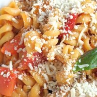 vegan one pot pasta with mushrooms tomatoes spinach and roasted red peppers with plant based cheese