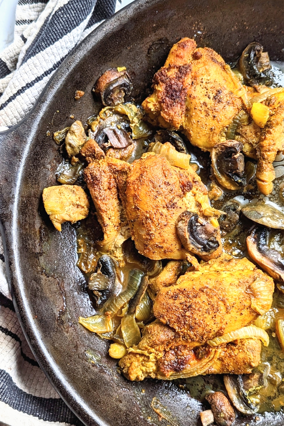 turmeric chicken with black pepper in a skillet with onions and mushrooms roasted in the oven keto low carb whole30 and paleo