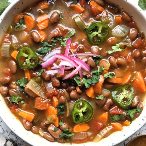 vegan pinto bean soup recipe plant based bean soups with jalapeno carrots and pickled onions in a white bowl.