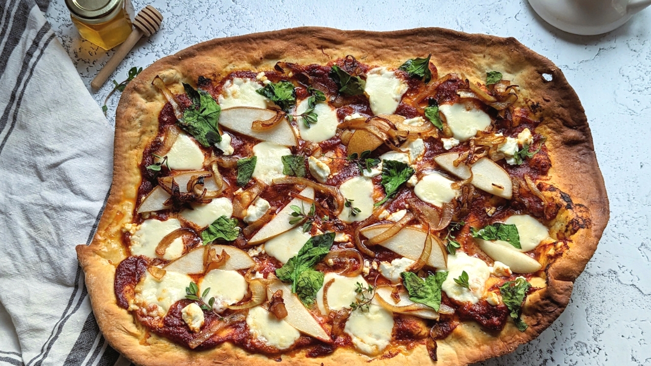 pizza with goat cheese and honey and caramelized onions with pears thyme and red sauce and crust