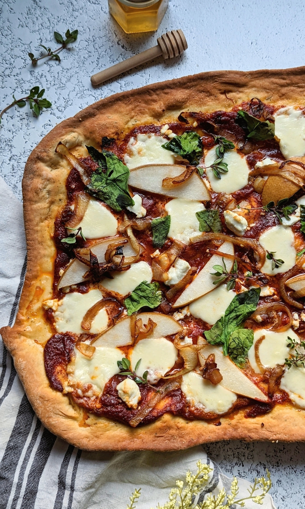caramelized onion and goat cheese pizza with honey pears and red sauce