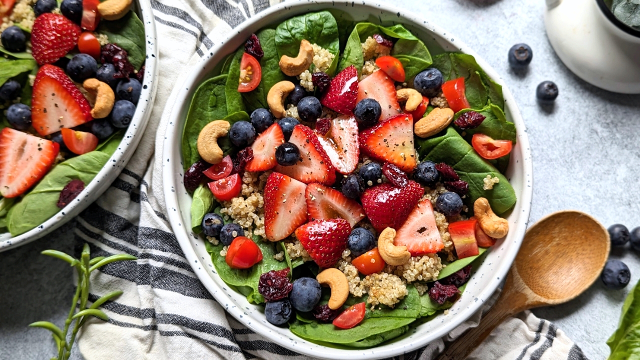 strawberry spinach salad with blueberries, cashews, quinoa, and cranberries for a summer side salad with fruit