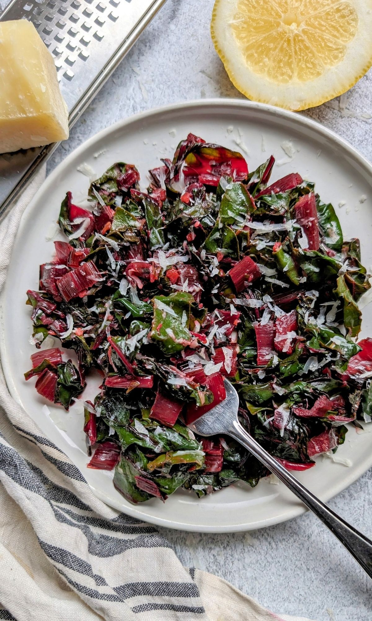 rainbow swiss chard sauteed with parmesan cheese and lemon and garlic on a plate ready in 20 minutes