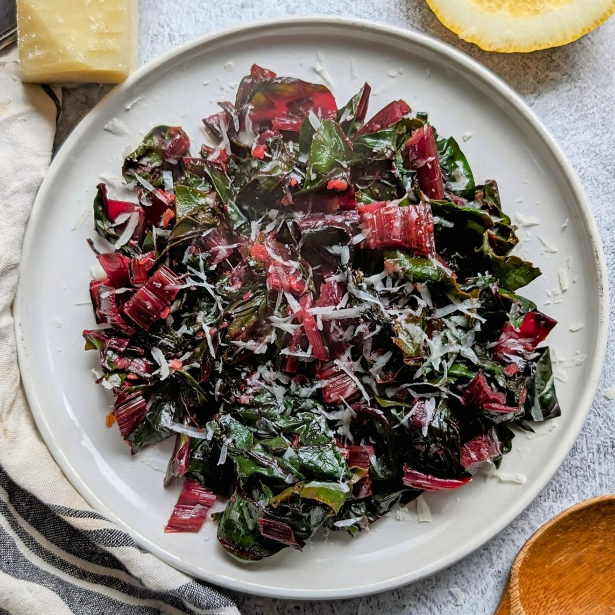sauteed swiss chard with parmesan cheese and lemon with garlic in a pan