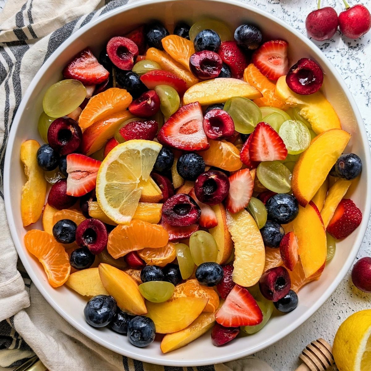 honey lemon fruit salad recipe with peaches, oranges, strawberries, blueberries, and lemon dressing