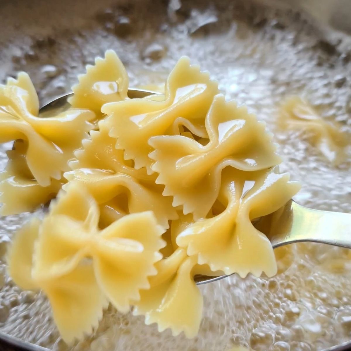 farfalle bowtie noodles cooking in boiling water for pasta salad.