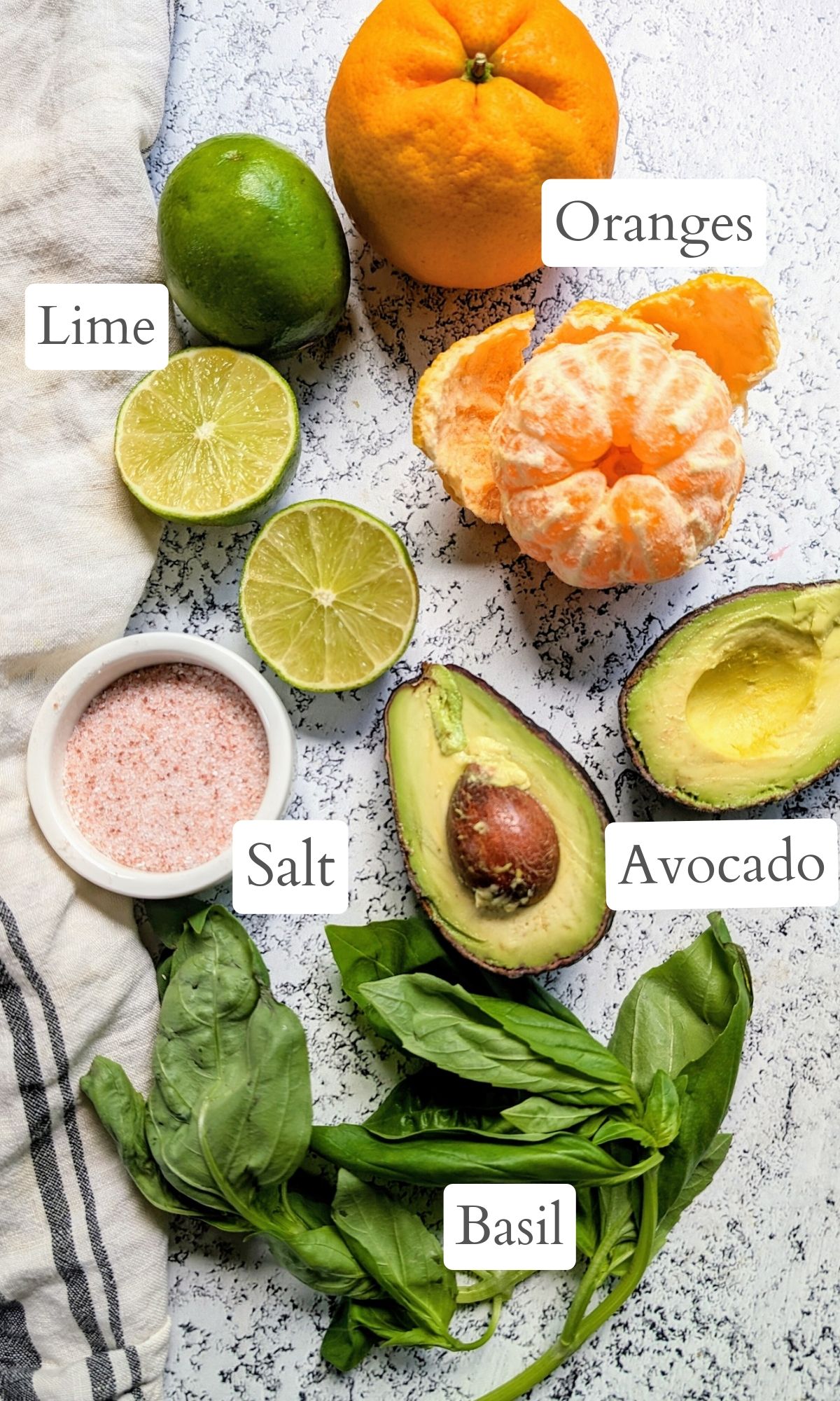 ingredients for this orange avocado salad including limes salt and fresh basil