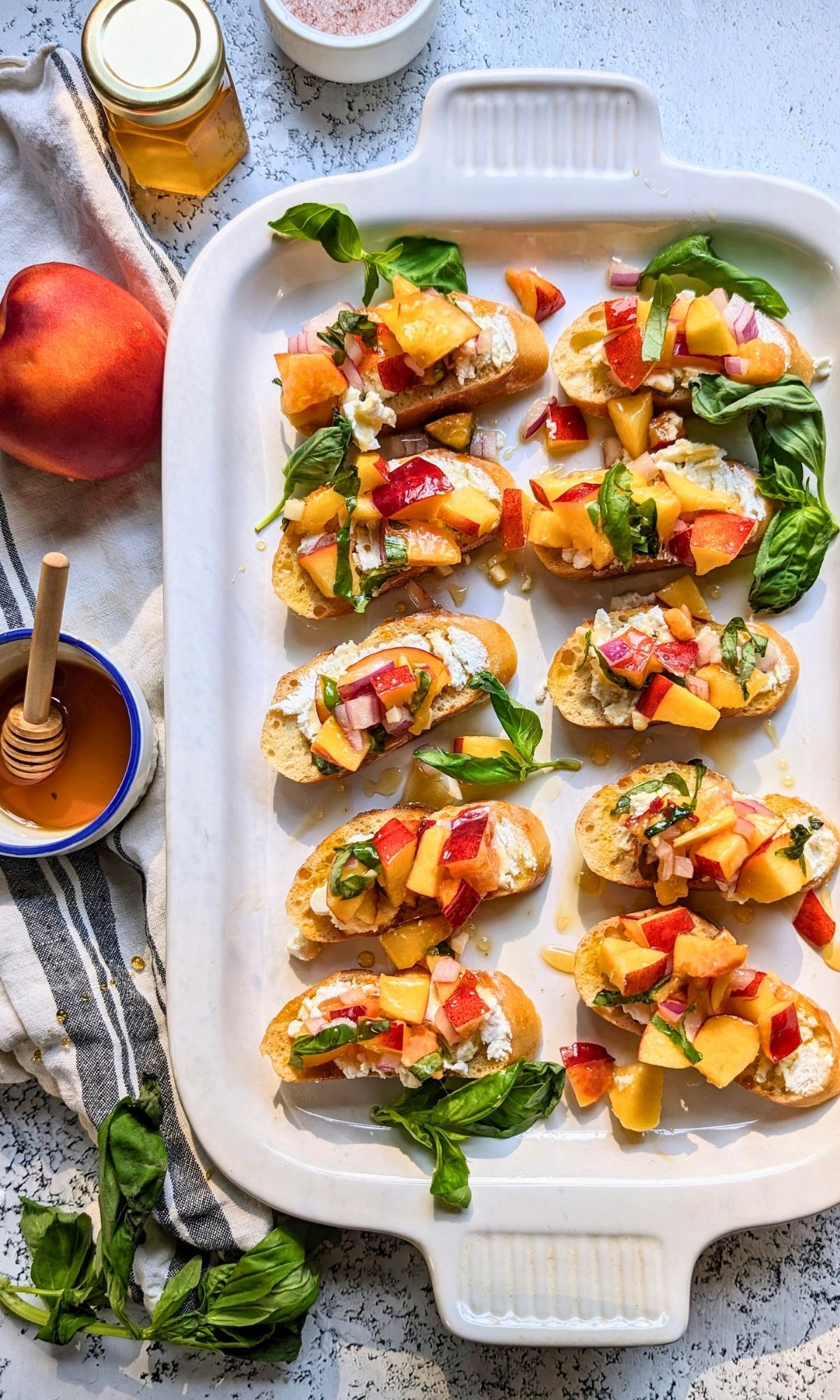 summer bruschetta with fruit on a plate fancy appetizers with toast peaches goat cheese and honey and basil vegetarian hors d'ouerves.
