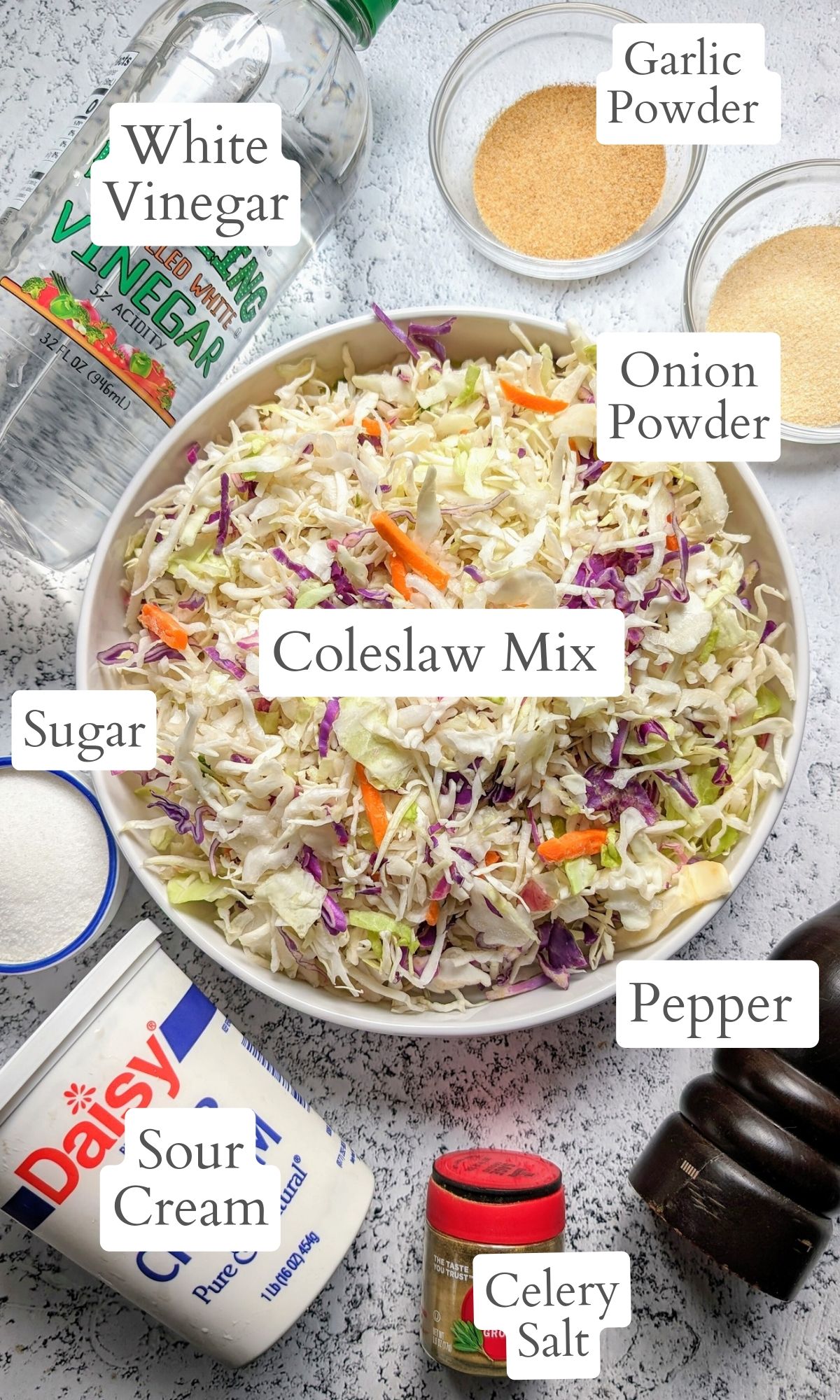 sour cream coleslaw ingredients laid out like white vinegar, onion powder, garlic powder, sugar, and celery salt and pepper.