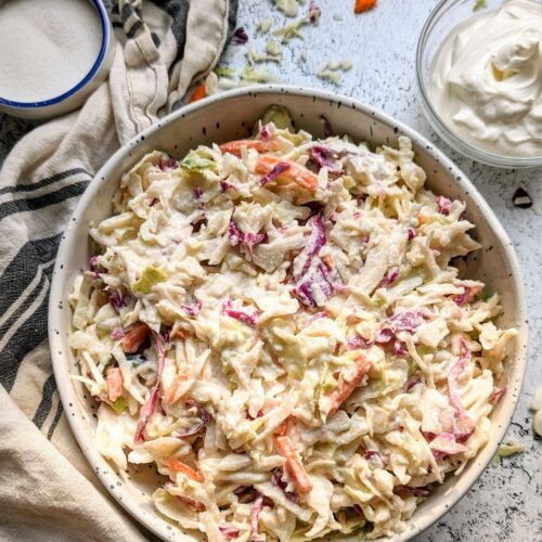 coleslaw with sour cream and no mayo creamy coleslaw in a bowl with shredded cabbage and carrots.