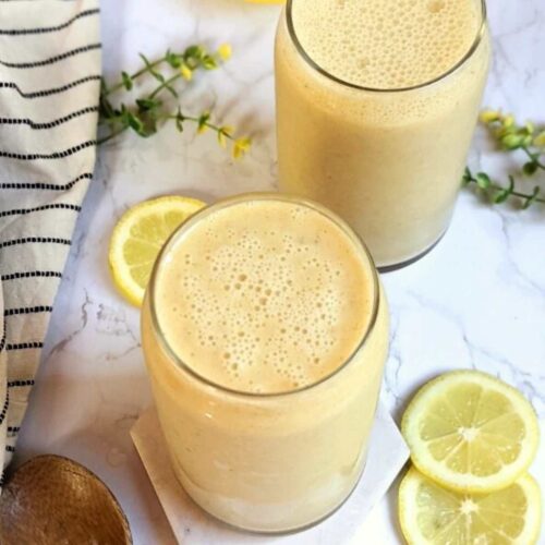 lemon smoothie with whole lemon in a glass with protein powder.
