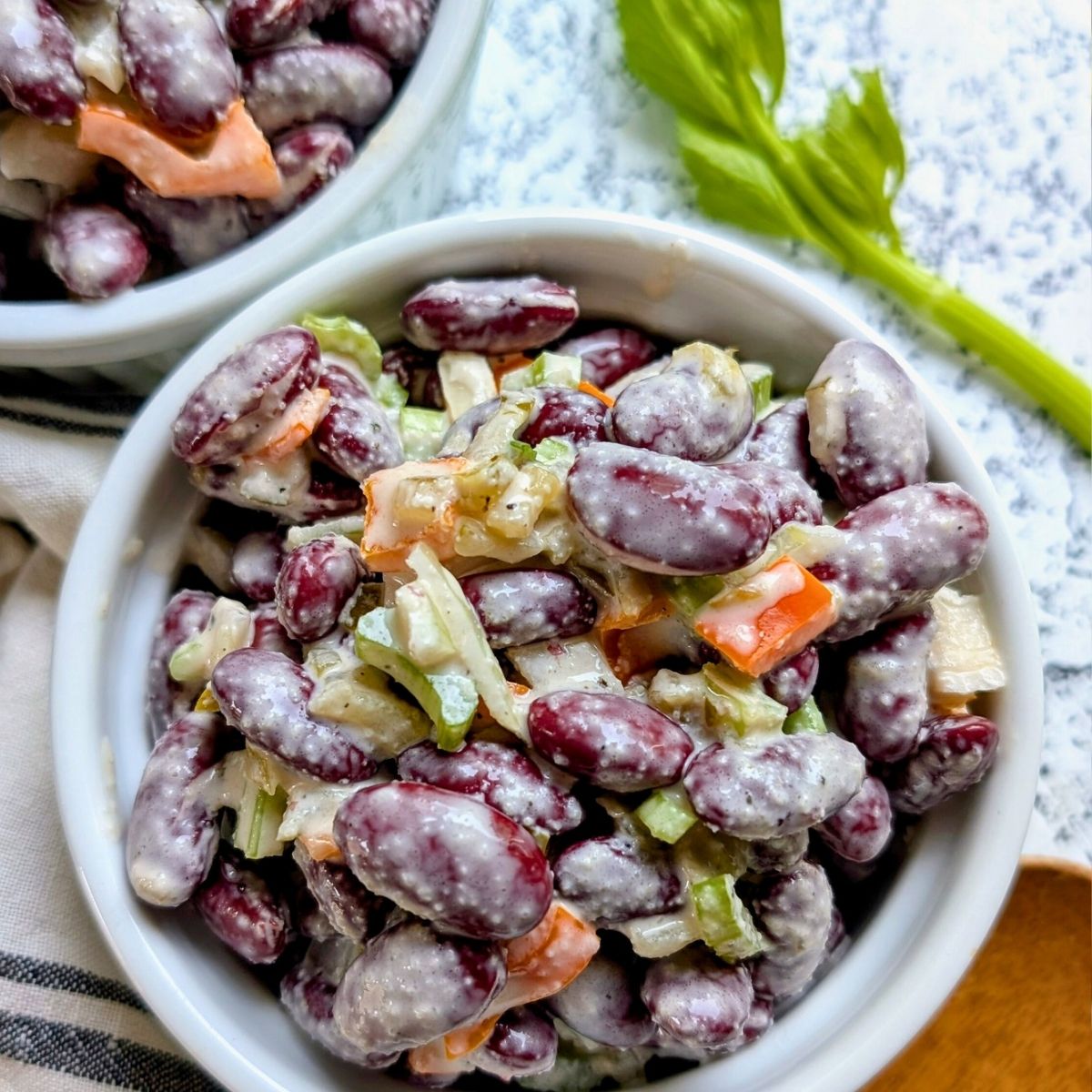 creamy kidney bean salad recipe in a bowl with dark red kidney beans bell peppers celery in a creamy mayo dressing.