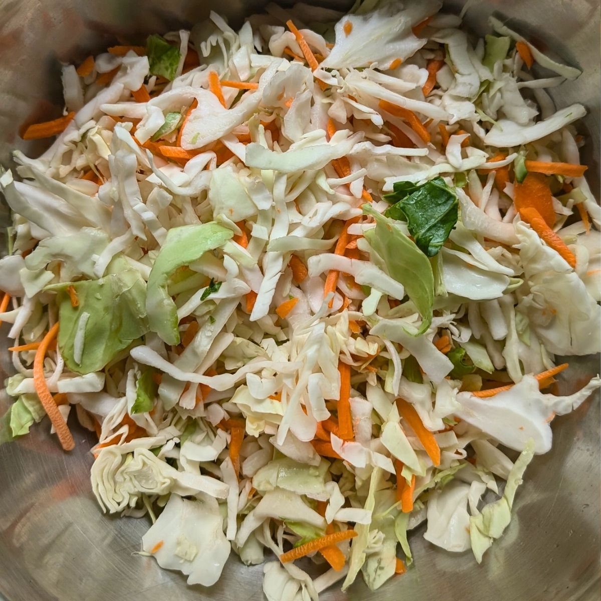 coleslaw mix with carrots and cabbage in a large mixing bowl for a salad.