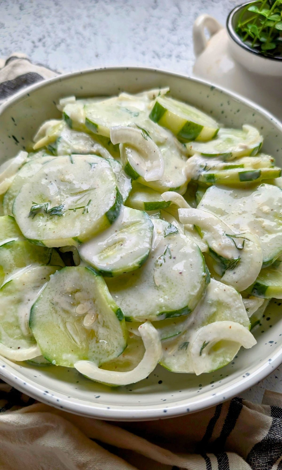 creamy old fashioned cucumber salad with sour cream, sugar, and dill with sliced onions for a summer bbq or party side dish.