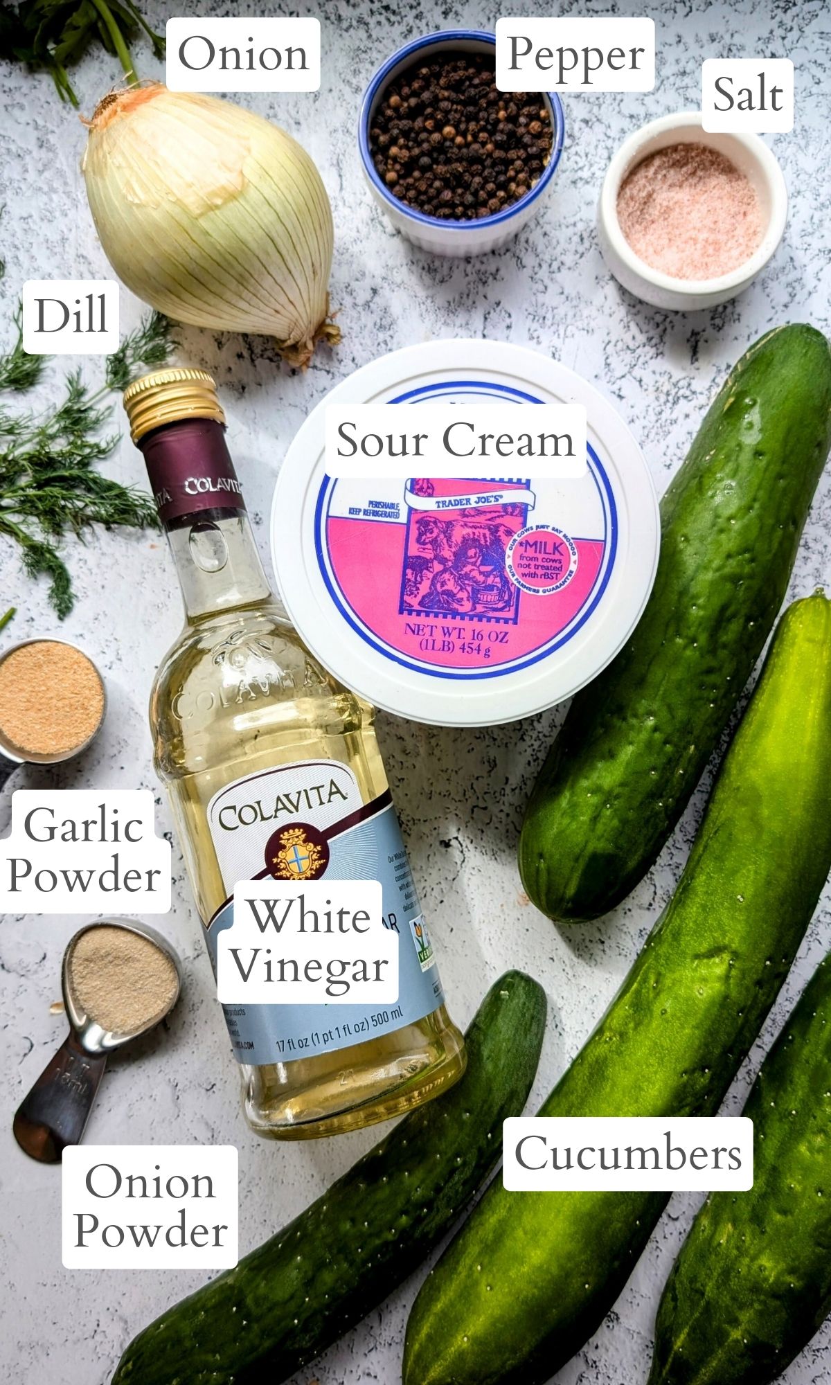 ingredients for a sour cream cucumber salad with fresh dill onions sugar cucumbers onion powder and garlic powder.