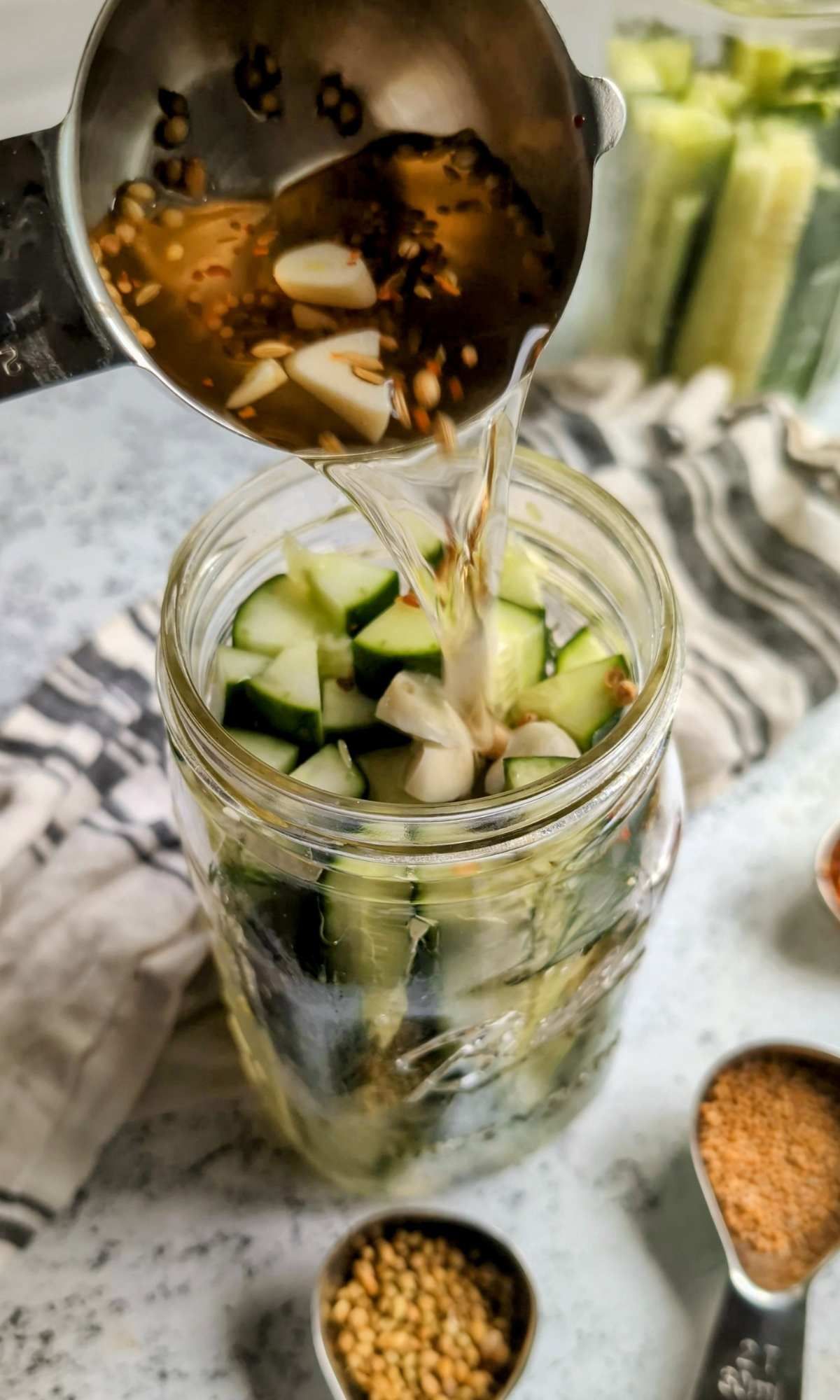 brine poured into a jar of sliced cucumbers to make tasty dill-free pickles.