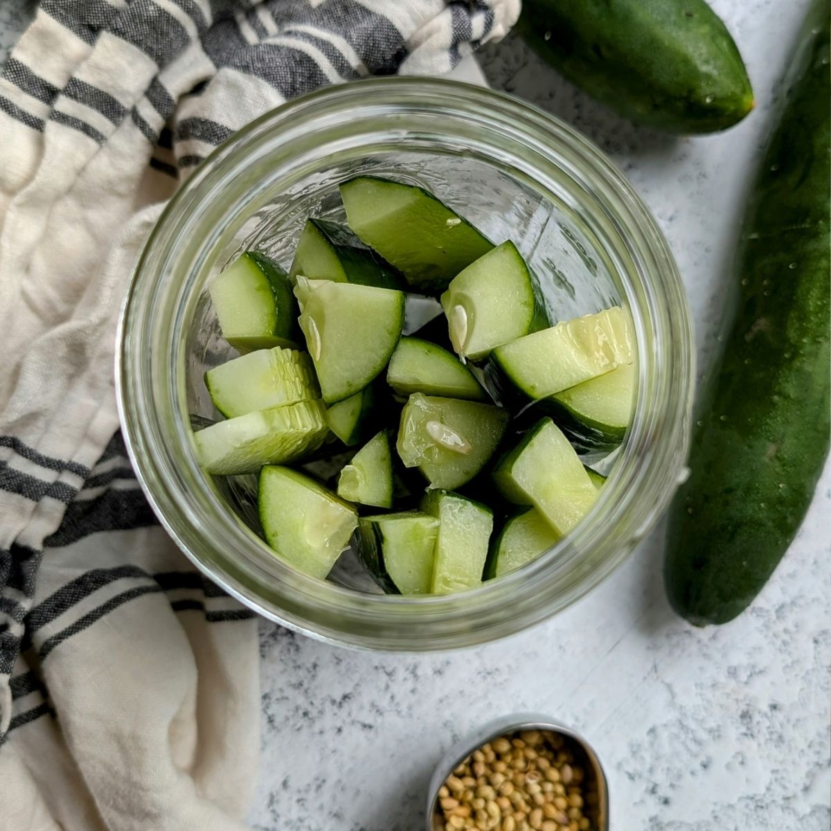 sliced cucumbers in a jar ready for brine.