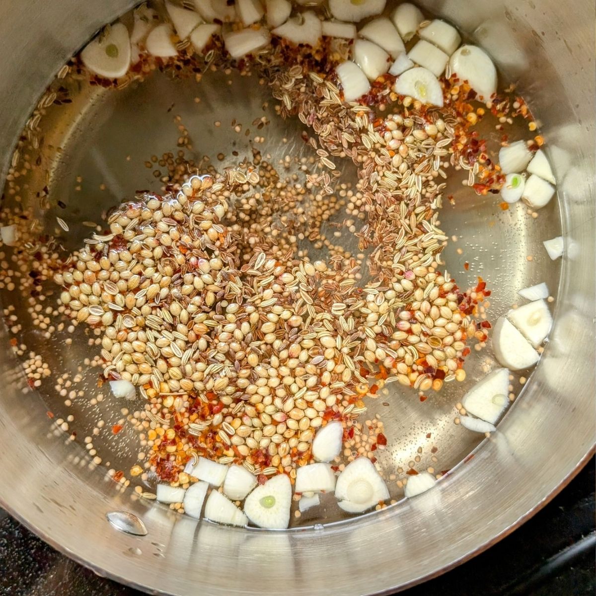 pickle brine with vinegar, water, garlic, mustard seed, fennel seed, and chili flakes.