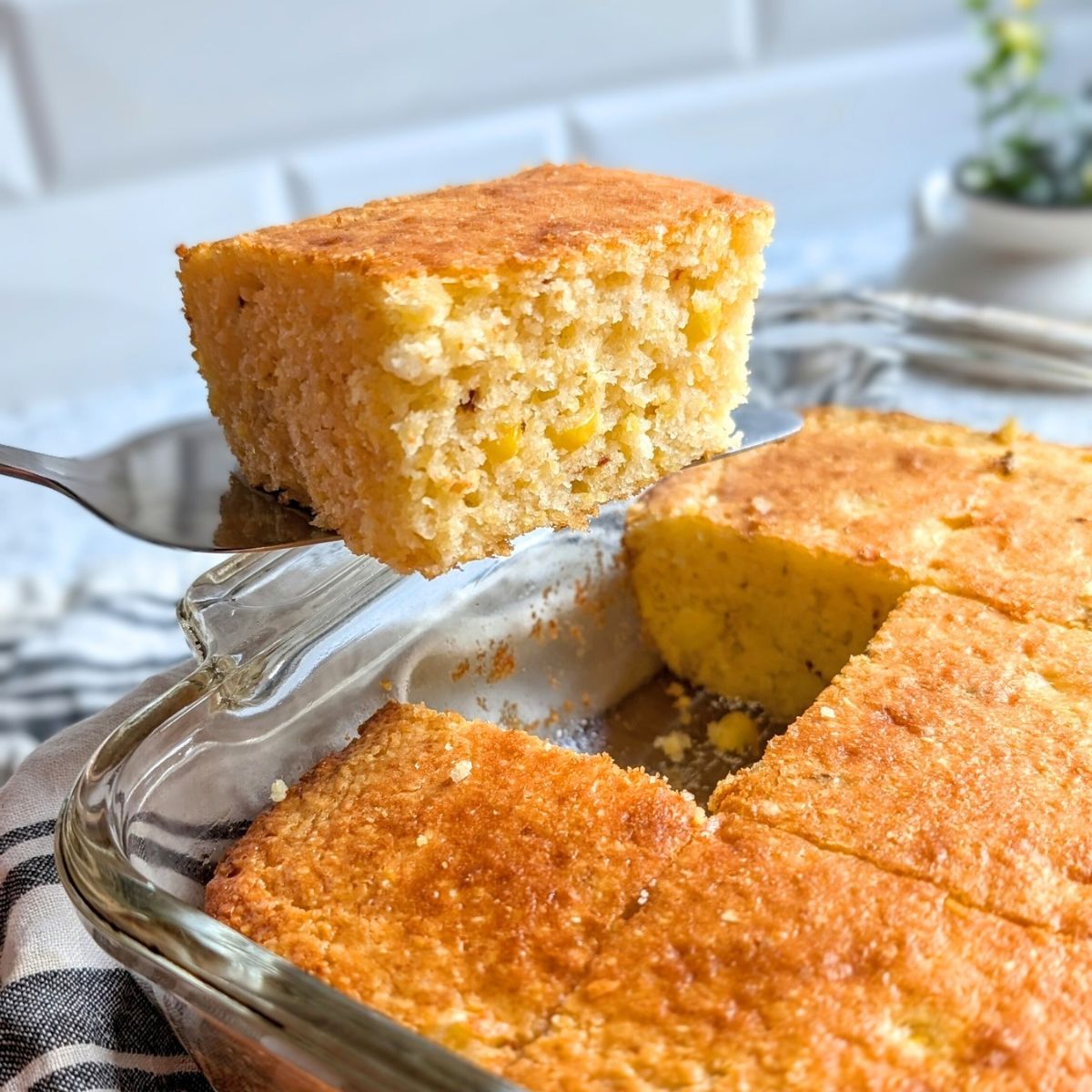 sliced cornbread with greek yogurt sliced into thick slices with a serving utensil.