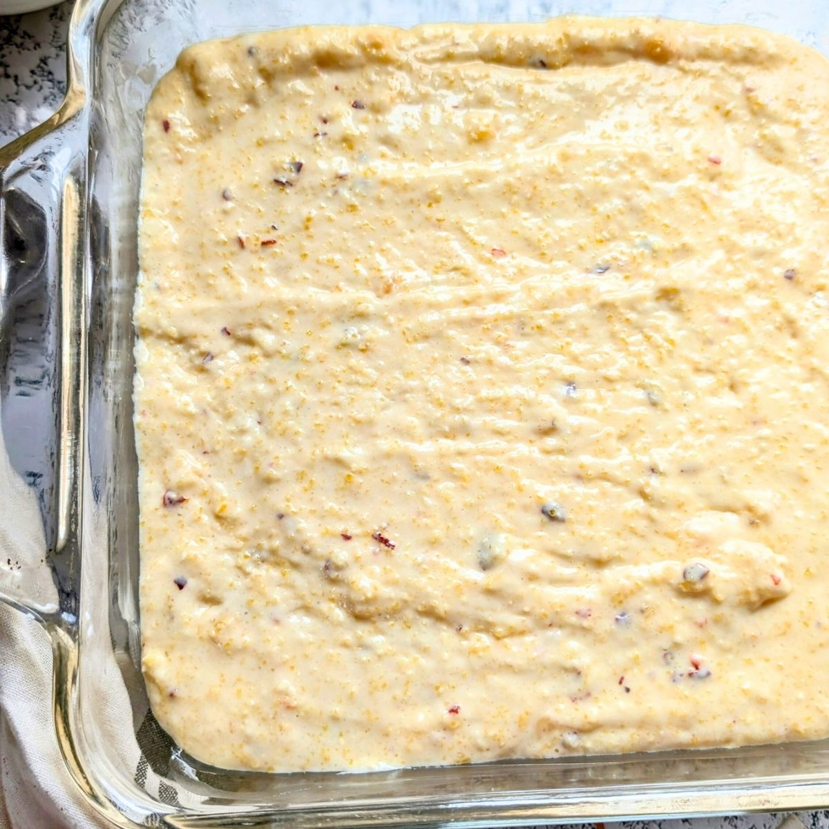 cornbread batter in a 8x8 inch baking dish for a tasty side dish that is high in protein.