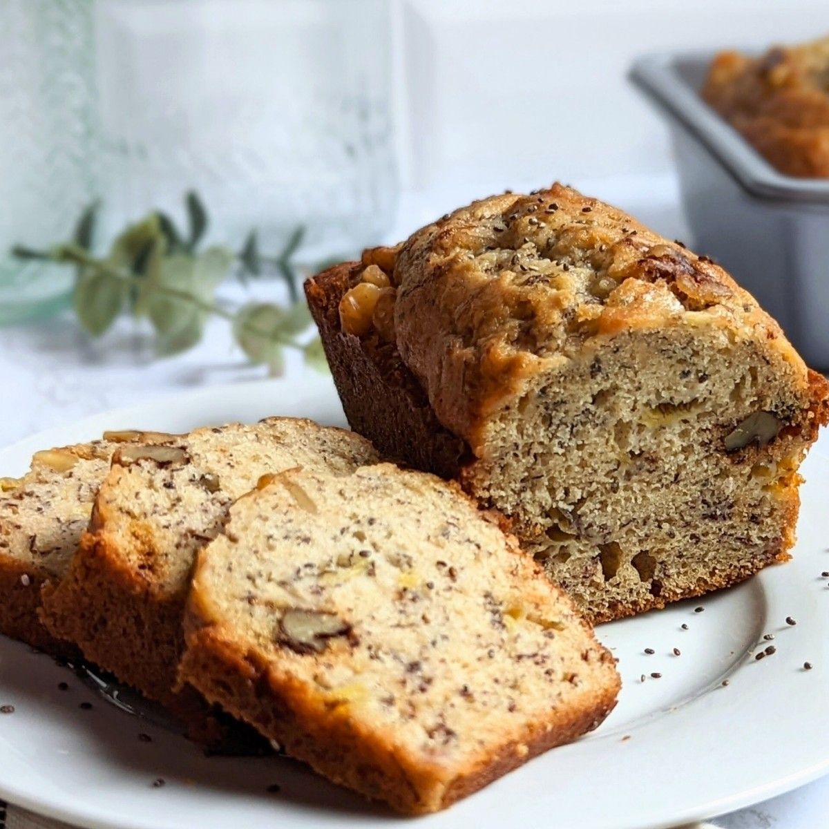 chia seed banana bread recipe easy and easy recipes for mashed bananas baking with banana in mini loaves or muffins, sliced on a plate with a mini loaf of banana bread in the background.