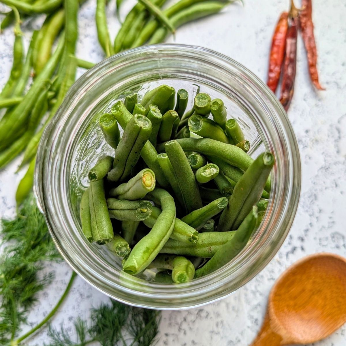 fresh green beans in a mason jar ready to be pickled.