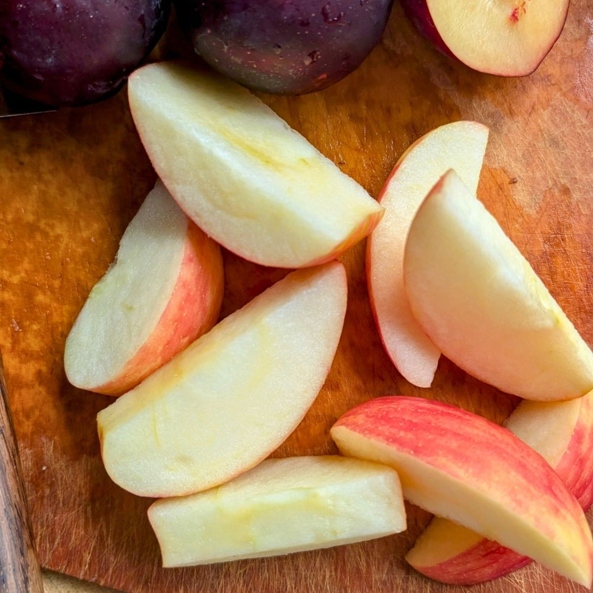 apples cored and sliced into pieces that fit into a juicer.