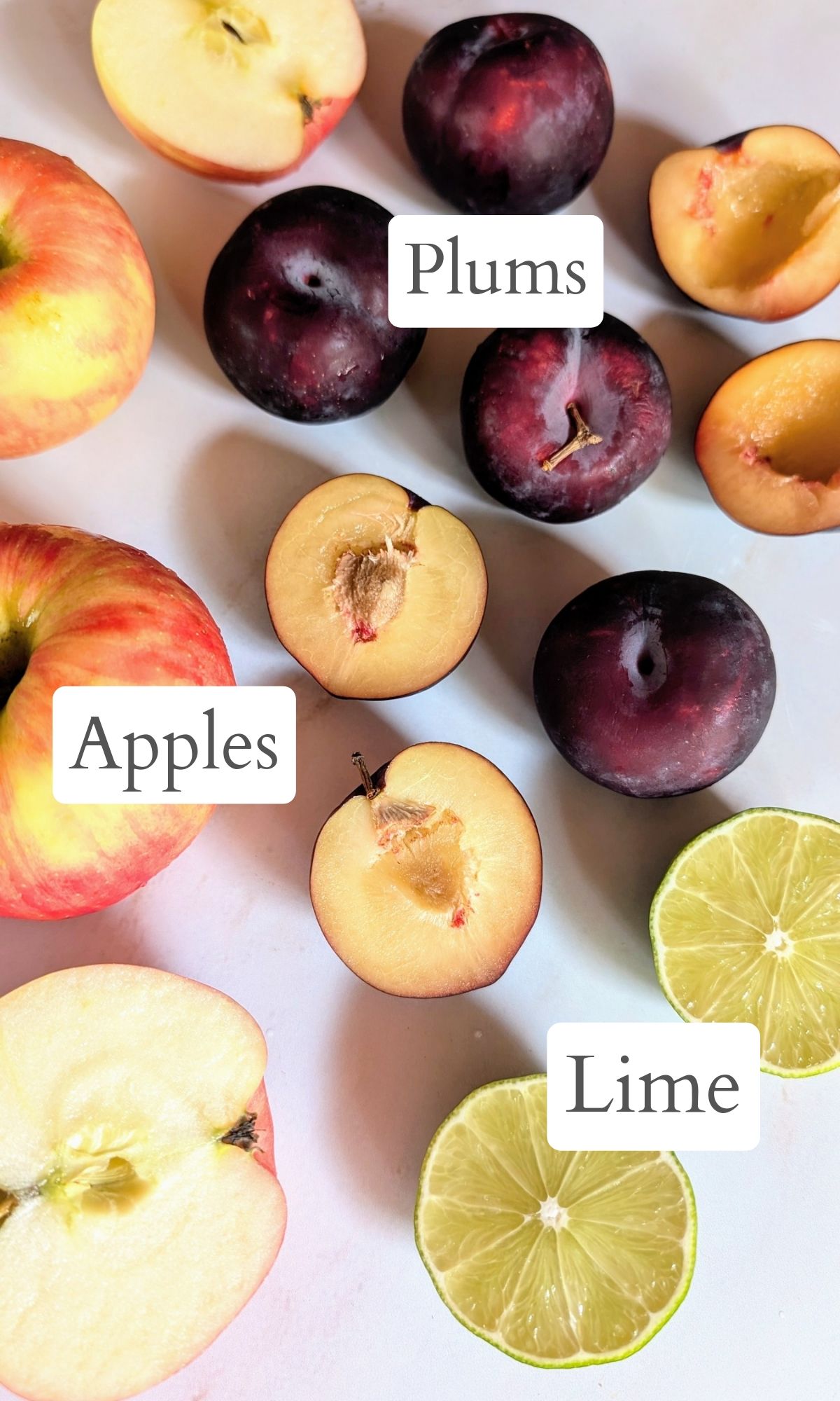 ingredients for plum juice in the juicer with fresh plums honeycrisp apples and fresh limes