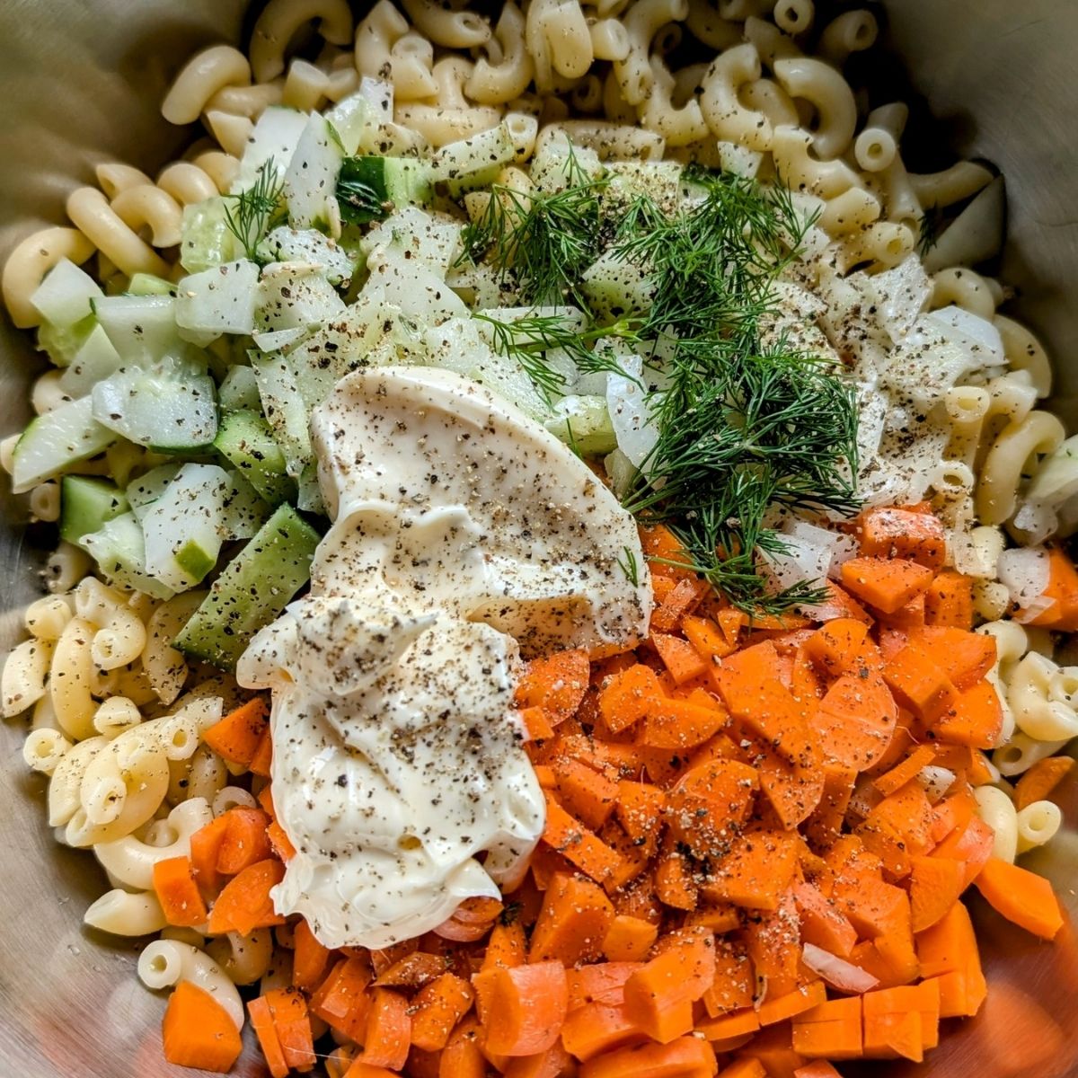 creamy cucumber pasta salad with dill carrots onion and white wine vinegar dressing.