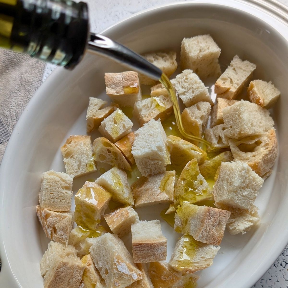 sourdough cubes tossed with olive oil in a baking dish to be broiled and toasted for panzanella salad.