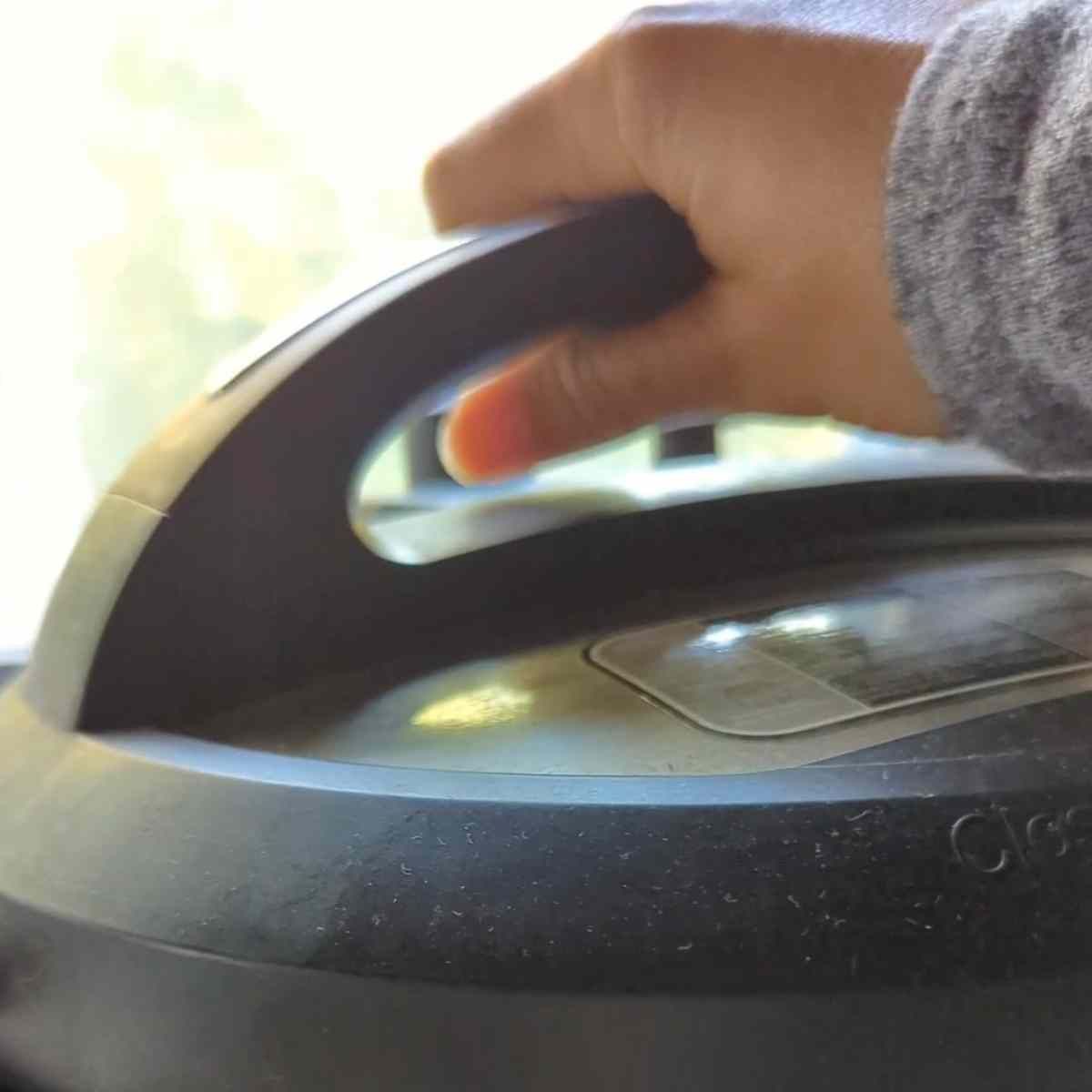 a hand closing an instant pot lid in a beautiful kitchen space.