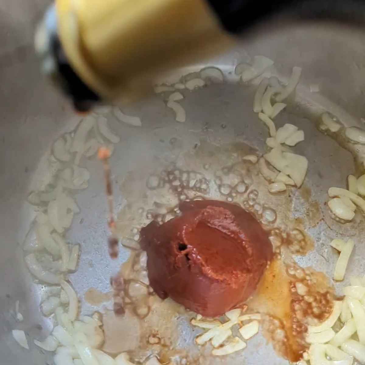 tomato paste and balsamic vinegar being added to the instant pot to make baked ziti pasta.