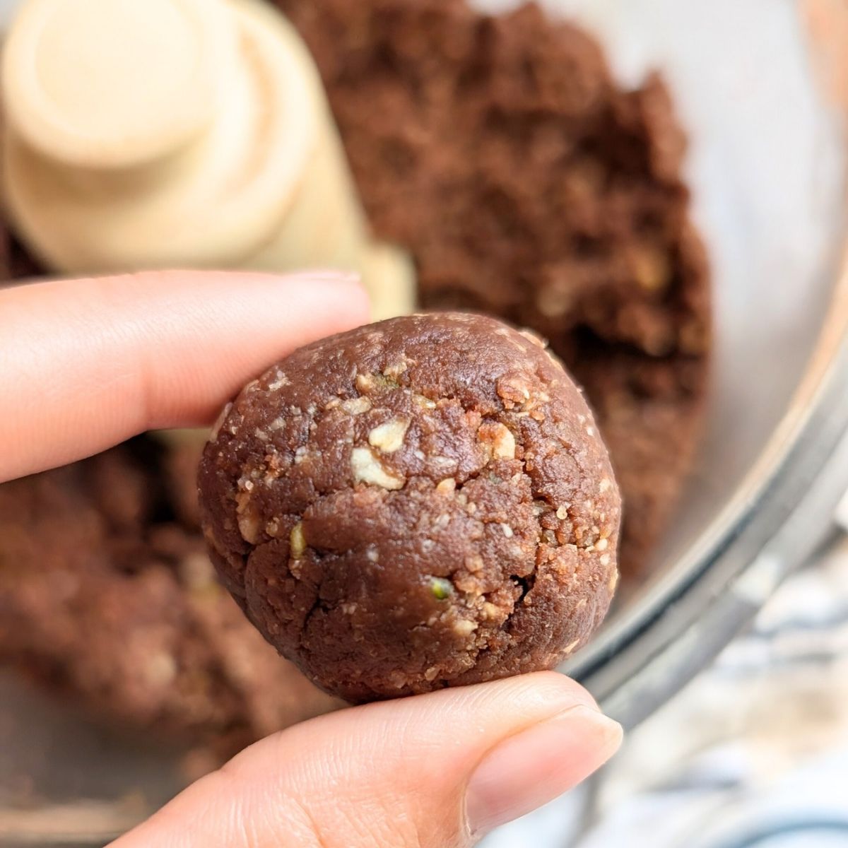 a chocolate oat ball rolled with hands.