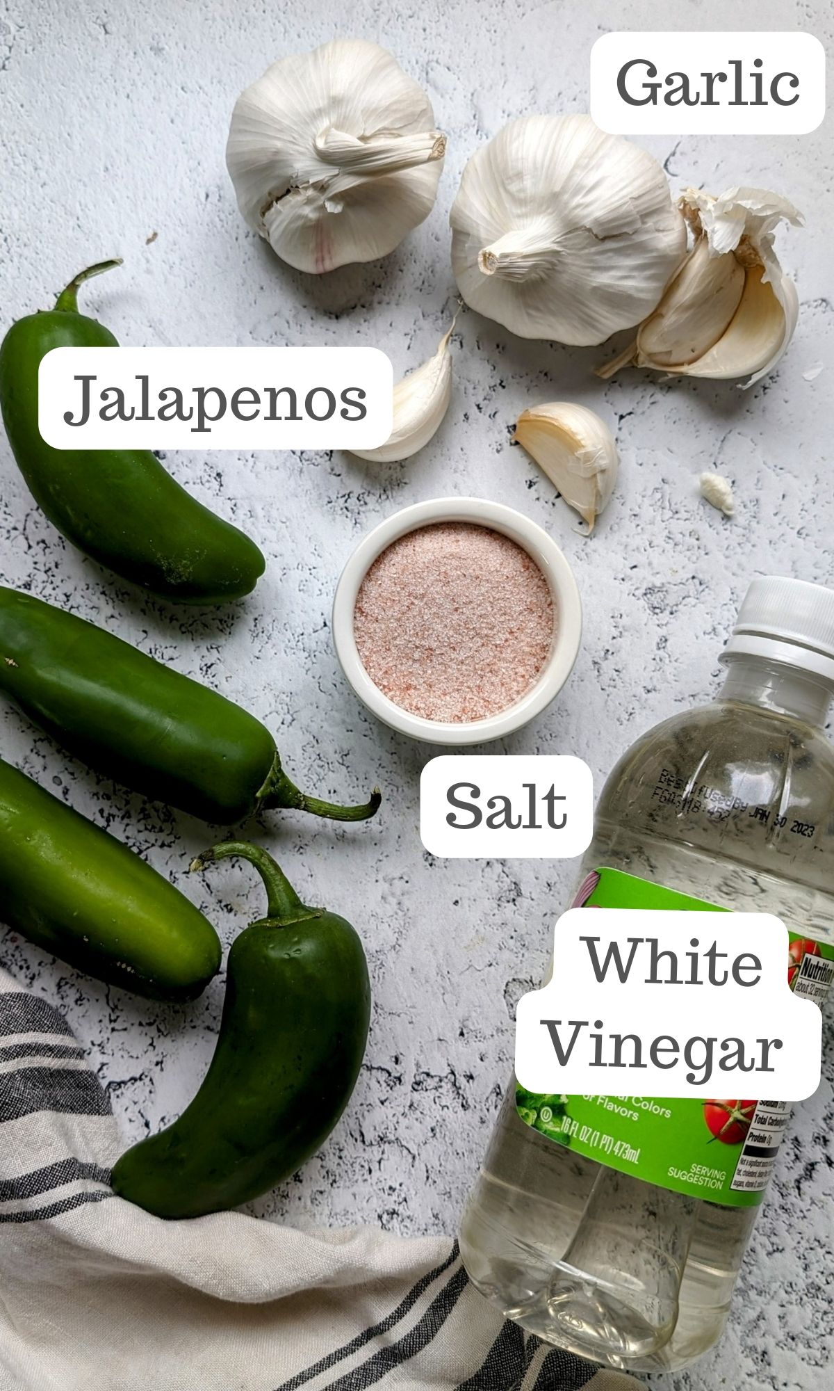 ingredients for hot sauce with jalepeno peppers including fresh jalapenos , salt, white vinegar, and garlic.