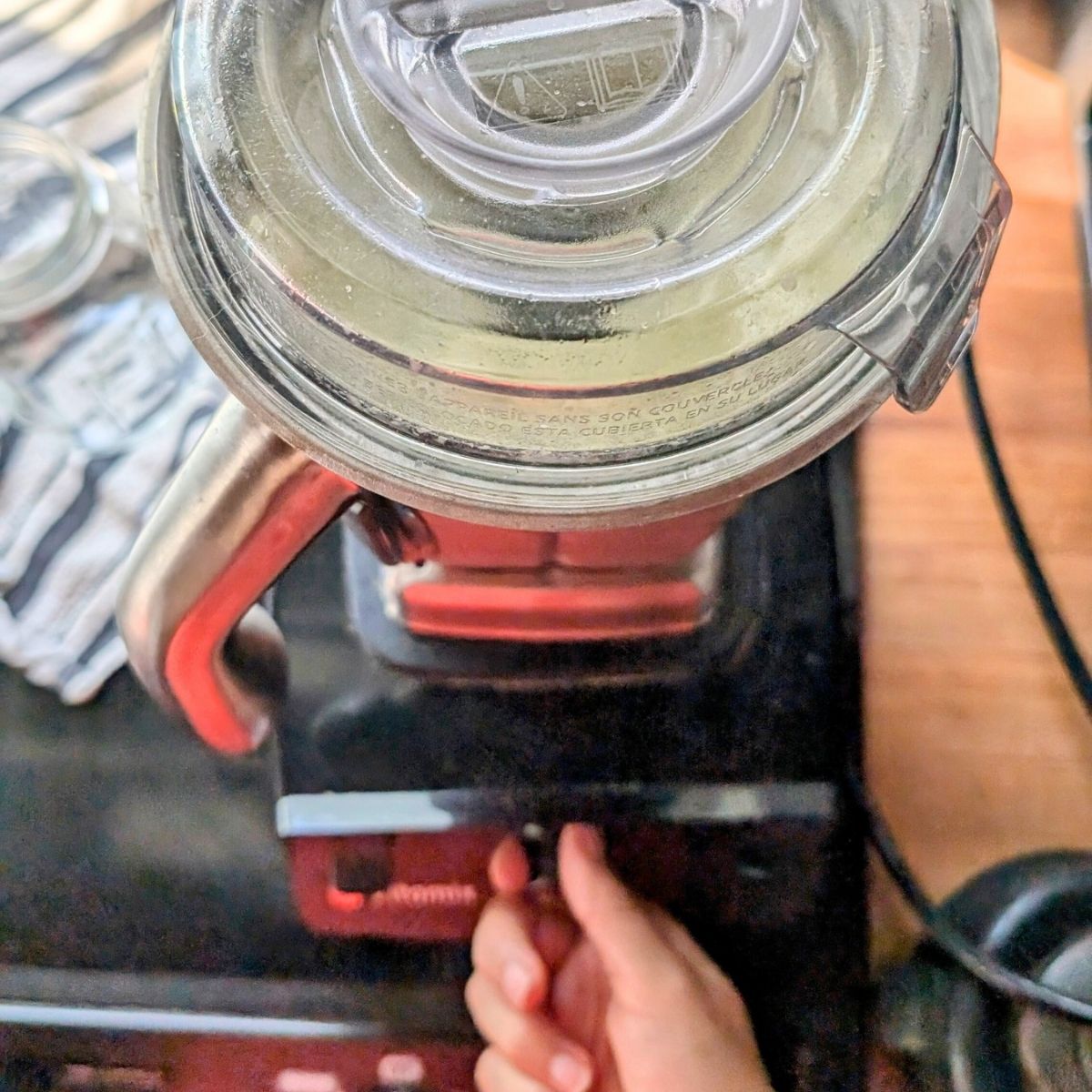 a vitamix blender with a stainless steel container making a kiwi smoothie for breakfast.